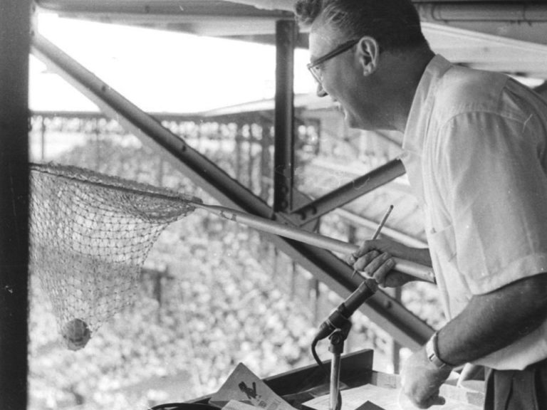 Harry Caray catches a foul ball in a net
