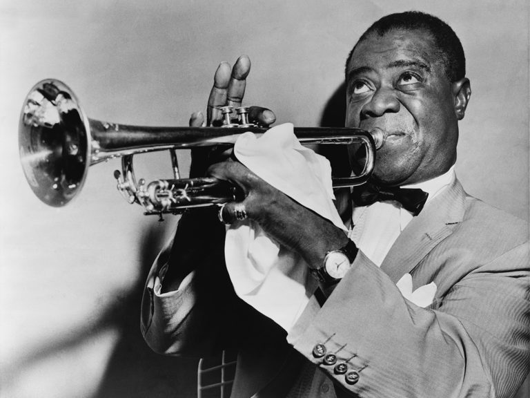 Louis Armstrong playing trumpet, with focused expression