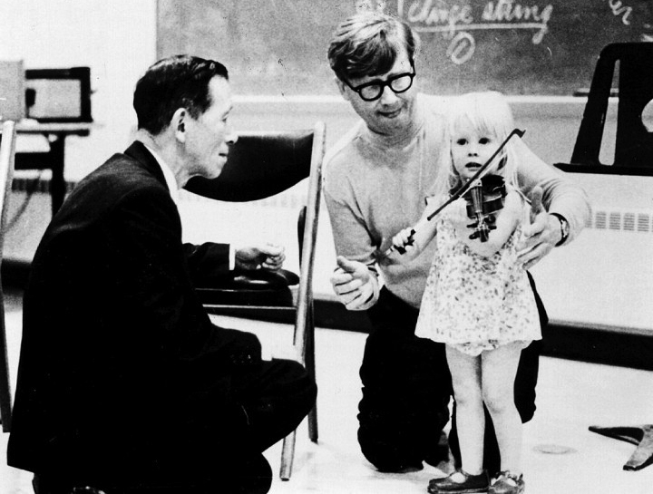 Shinichi Suzuki (pictured left) helps a girl to learn violin