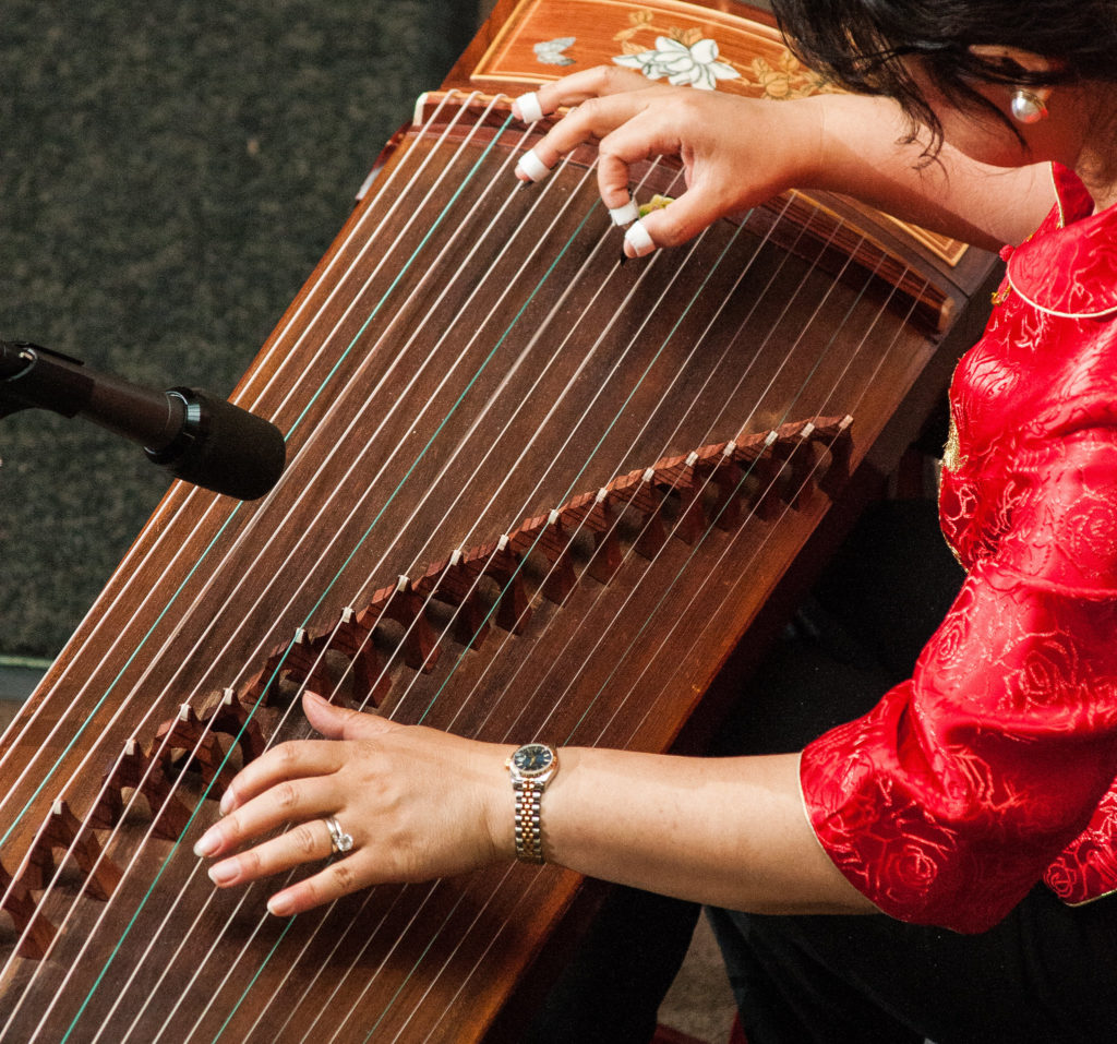 A performer plays the Chinese guzheng, part of the vast string instrument family